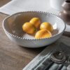 set of four white porcelain pasta bowls with an uneven rustic shape and beaded edging