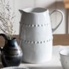 vintage white porcelain jug with an uneven rustic shape and beaded design