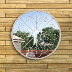 round metal outdoor mirror with cream frame and scroll design