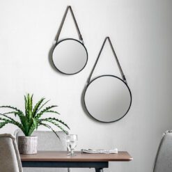 set of two industrial style round hanging wall mirrors with black metal frames and faux leather straps