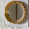 round gold wall mirror with a deep wide frame