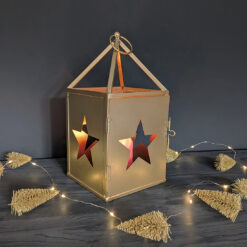 rustic metal square lantern with a large cut-out star on each side finished in a matt gold