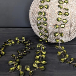 jewel garland with teardrop shaped green crystals with a reflective silver mirror backing attached to gold wire