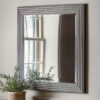 decorative square wall mirror with a stepped ribbed wide frame and distressed silver finish