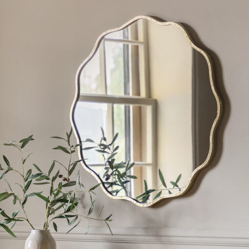 decorative round wall mirror with a wavy silm metal frame finished in gold leaf