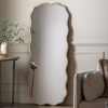 decorative full length leaner mirror with a wavy silm metal frame finished in gold leaf