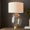 large oval glass table lamp with satin brass accents and vintage white drum lampshade