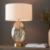 large oval glass table lamp with a textured dimpled champagne glass base, satin brass accents and a natural drum lampshade