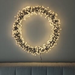 large contemporary black wire framed christmas wreath covered in hundreds of small opaque bulb LED lights - mains operated