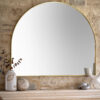 large arched overmantle wall mirror with a slim metal frame finished in warming gold