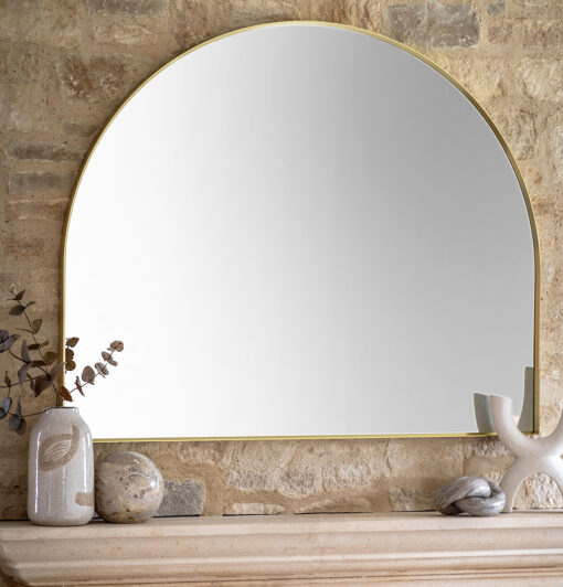 large arched overmantle wall mirror with a slim metal frame finished in warming gold