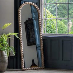 arched full length wooden mirror with a natural white-wash finish and a bold bobble design to the frame