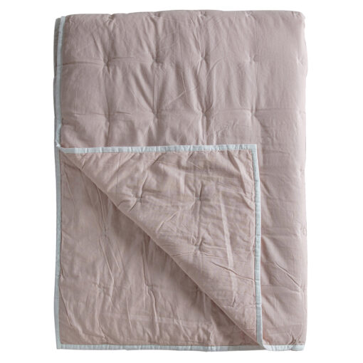 cotton blush pink bedspread with a white cross stitch design and flat pipe edging